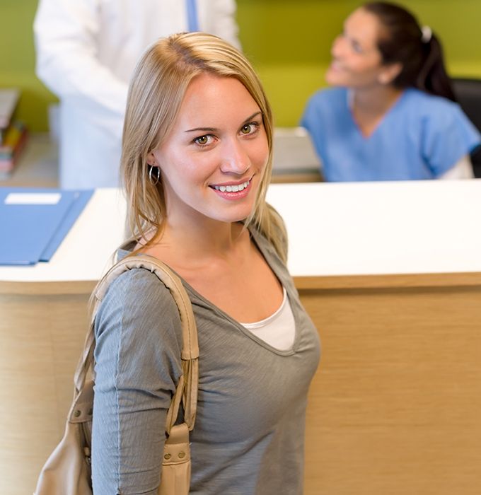 Smiling woman at dental office reception desk