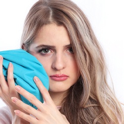 woman holding ice pack on jaw after dental implant surgery