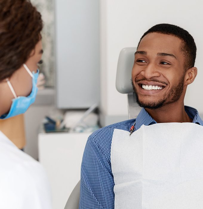 Man in dental chair smiling at dentist