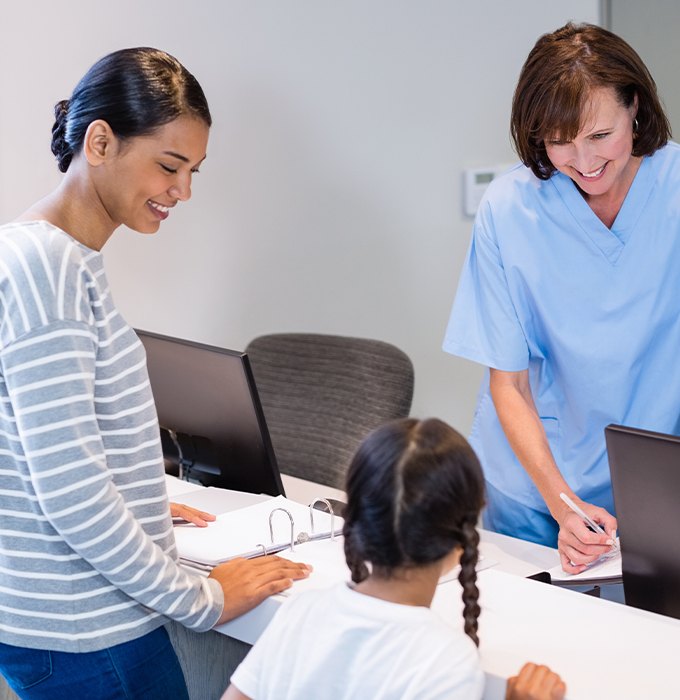 Mother and daughter filling out dental insurance forms