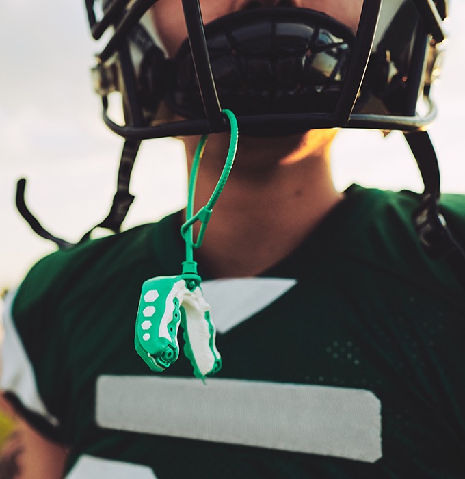 Athletic mouthguard hanging from football helmet