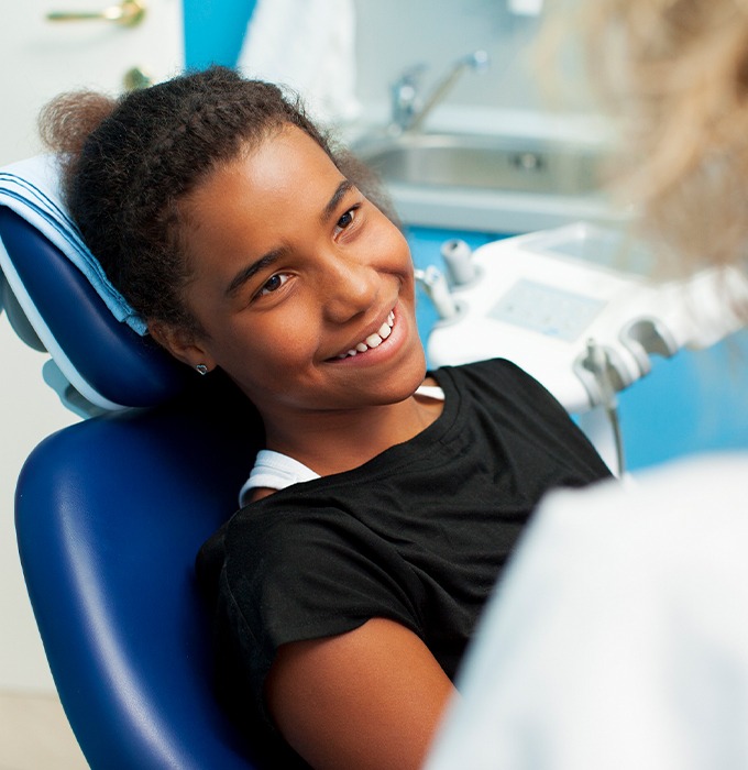 Girl smiling at dentist after treatment for damage from non nutritive habits