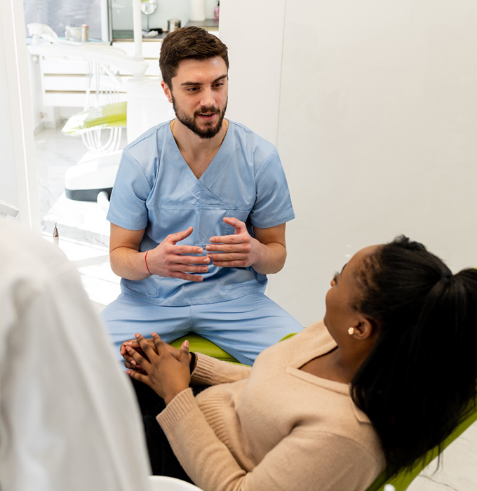 woman talking to cosmetic dentist in Flint 