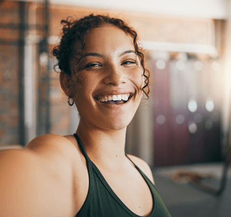 a woman smiling after receiving tooth-colored fillings in Flint