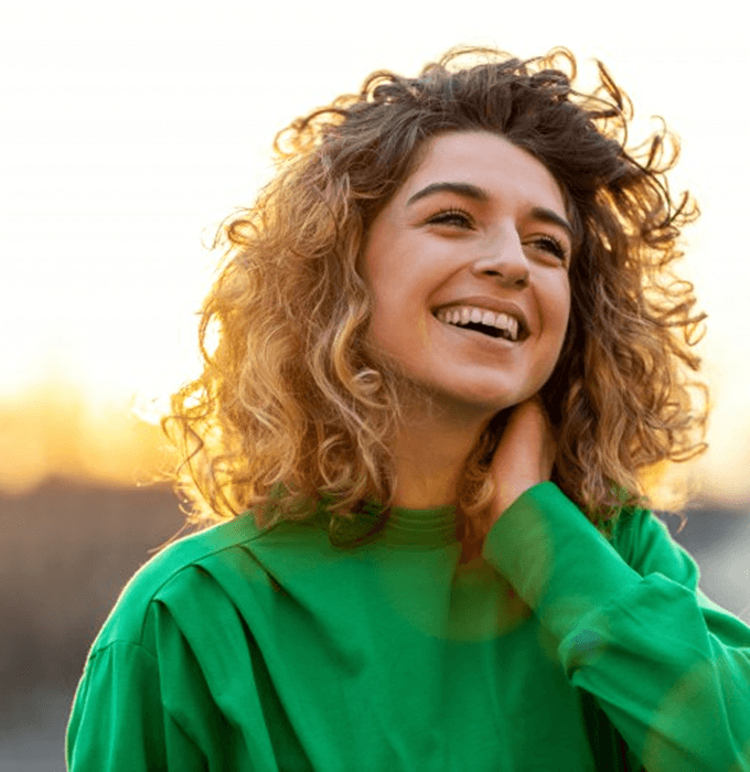 a woman smiling after receiving tooth-colored fillings in Flint