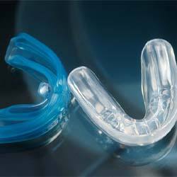 Blue and clear mouthguards with dark background