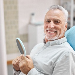 man smiling after getting dental implants in Flint