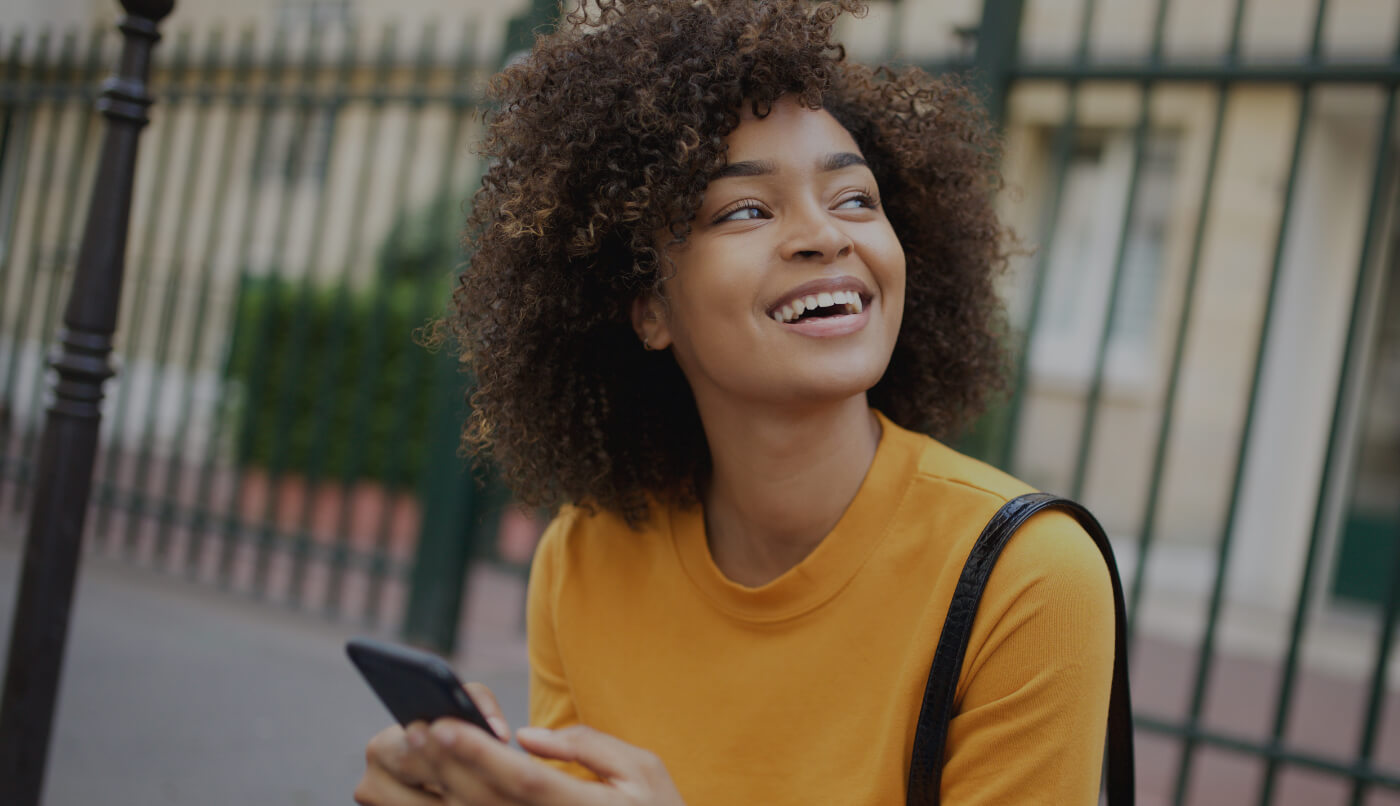 Woman with healthy smile using smartphone