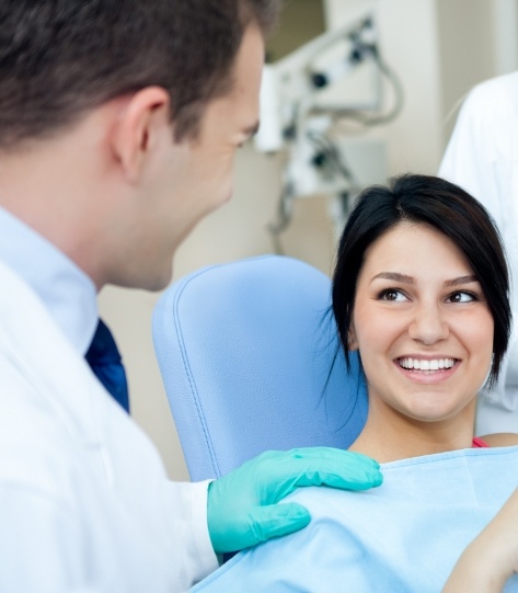 Woman in the dental chair smiling at her dentist