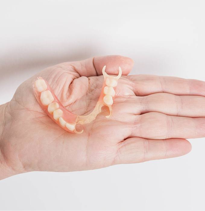 Hand holding a partial denture