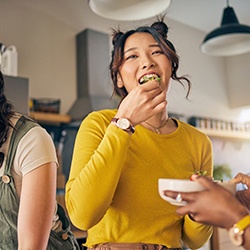 Friends smiling while eating together in kitchen