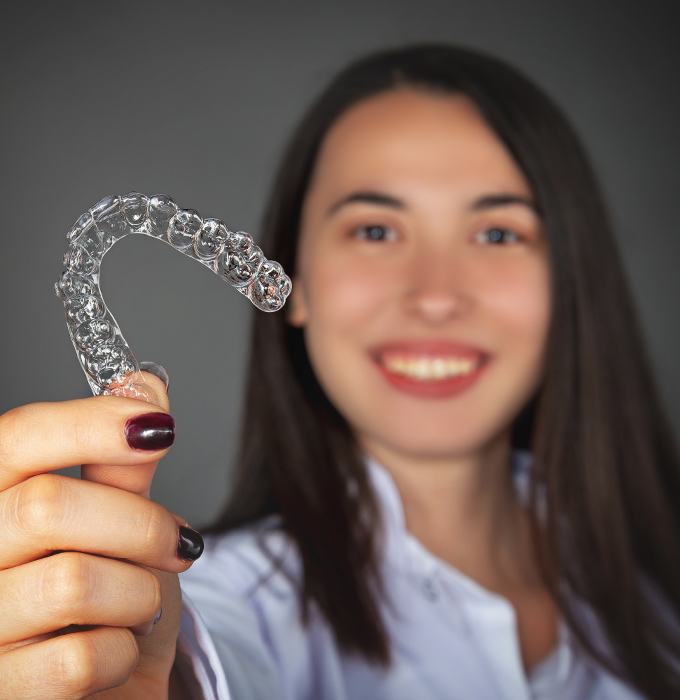 Woman holding up a clear nightguard