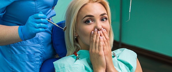 Woman in need of tooth replacement covering mouth