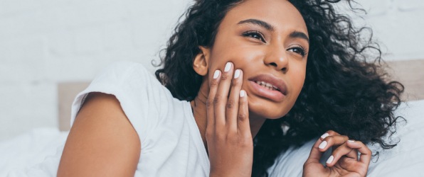 Woman in need of emergency dentistry holding jaw in pain