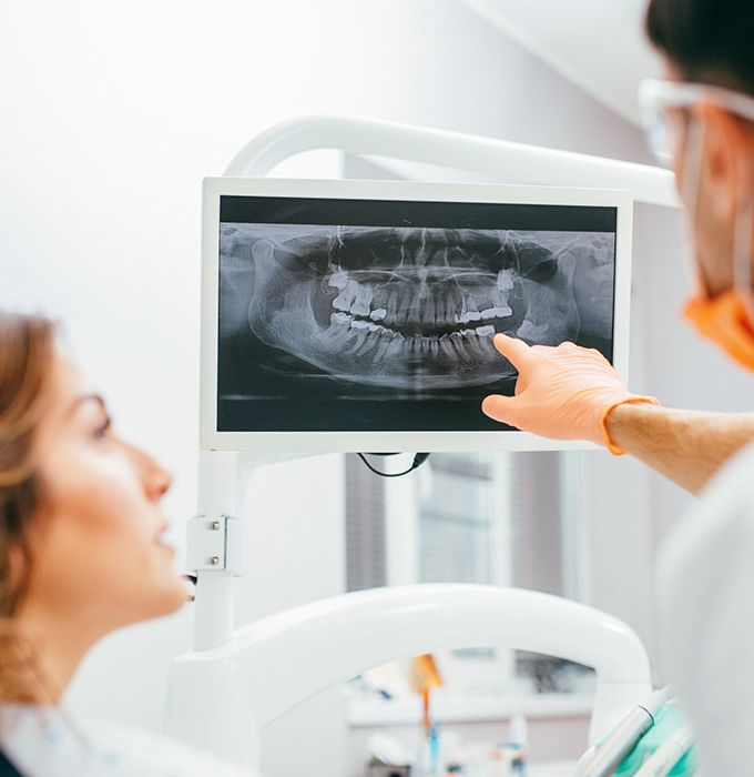 Dentist and patient looking at digital x-rays