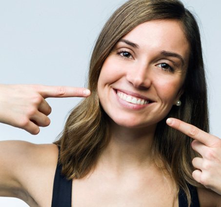 Woman pointing to her smile