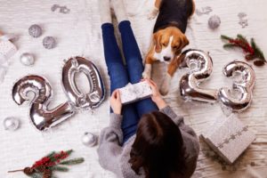 woman and dog with 2023 new year’s balloons 