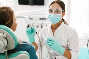 Dentist taking break from working on patient to smile. 